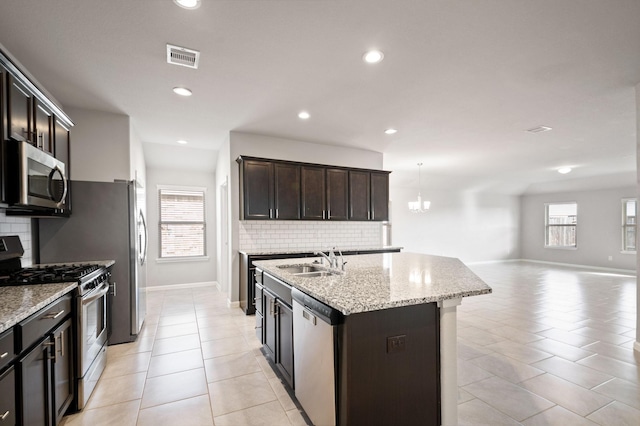 kitchen featuring backsplash, sink, an island with sink, and stainless steel appliances