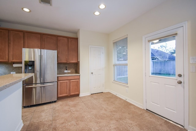 kitchen featuring stainless steel refrigerator with ice dispenser, tasteful backsplash, and light tile patterned floors