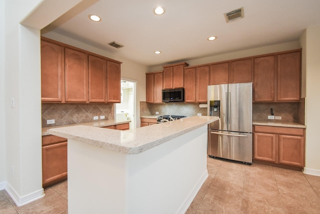 kitchen featuring decorative backsplash, light tile patterned floors, stainless steel appliances, and a kitchen island