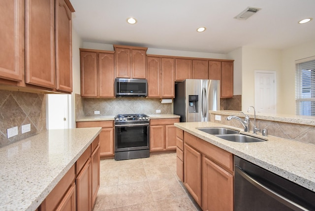 kitchen featuring sink, stainless steel appliances, light stone counters, backsplash, and light tile patterned floors