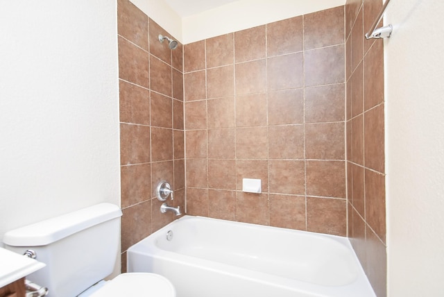 bathroom with tiled shower / bath and toilet