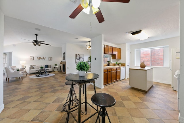 kitchen with white dishwasher, lofted ceiling, and sink