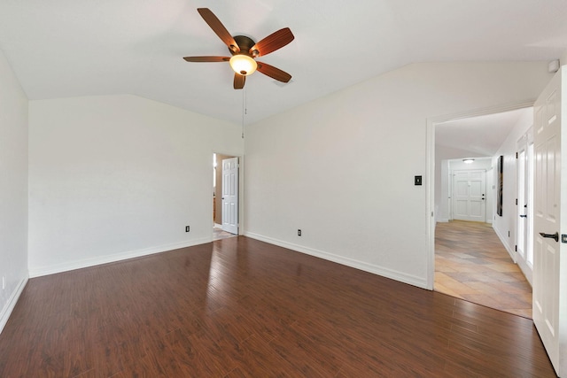 empty room with ceiling fan, dark hardwood / wood-style flooring, and vaulted ceiling