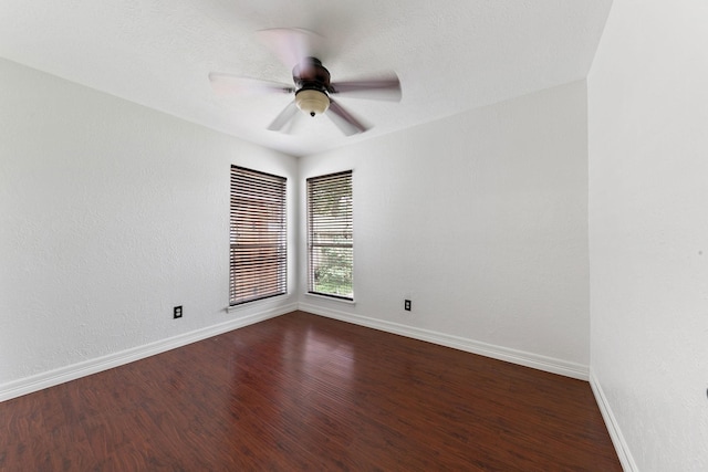 empty room with dark hardwood / wood-style flooring and ceiling fan