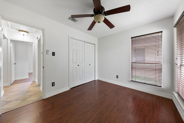 unfurnished bedroom with a closet, hardwood / wood-style flooring, and ceiling fan