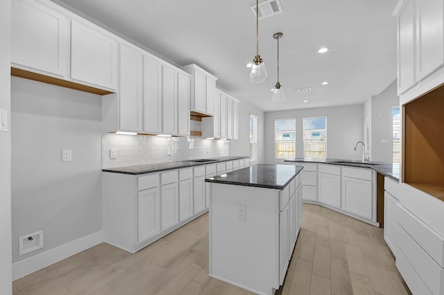 23411 Persimmon Creek Ln, Katy, TX 77493 - kitchen featuring sink, kitchen peninsula, hanging light fixtures, light hardwood / wood-style flooring, and white cabinetry