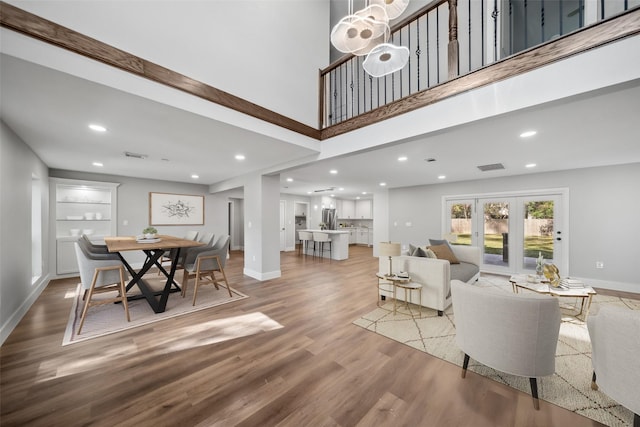 dining room featuring a high ceiling and light wood-type flooring