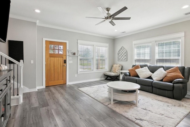 living room with hardwood / wood-style floors, ceiling fan, and ornamental molding