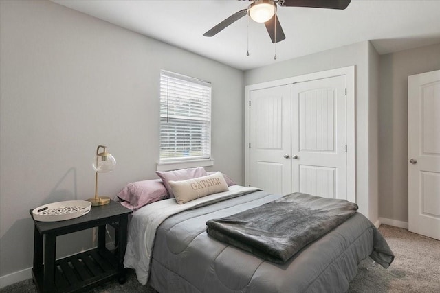 carpeted bedroom with ceiling fan and a closet