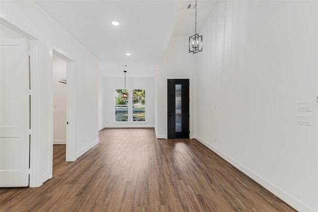 foyer entrance featuring dark hardwood / wood-style flooring and a notable chandelier