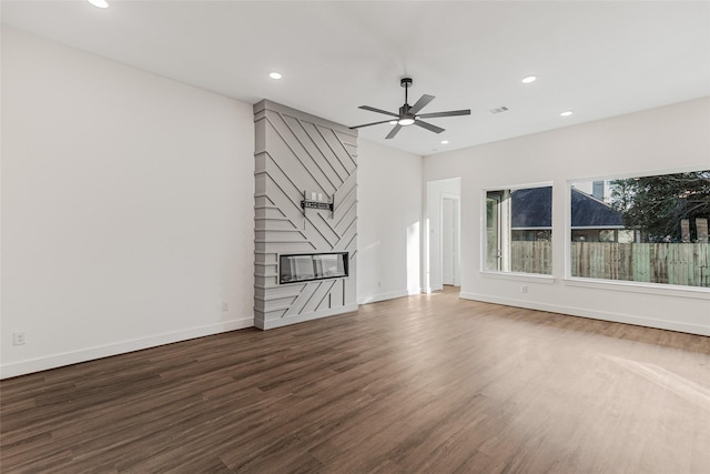 unfurnished living room with ceiling fan, a fireplace, and dark hardwood / wood-style floors