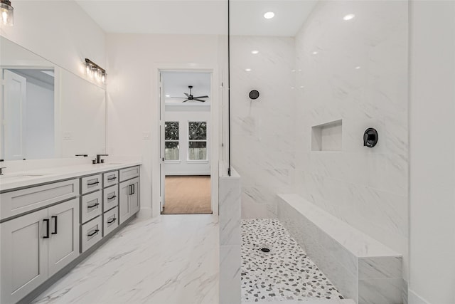 bathroom featuring ceiling fan, tiled shower, and vanity