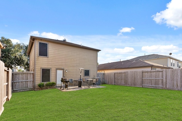 back of property with a patio area, a fenced backyard, and a yard