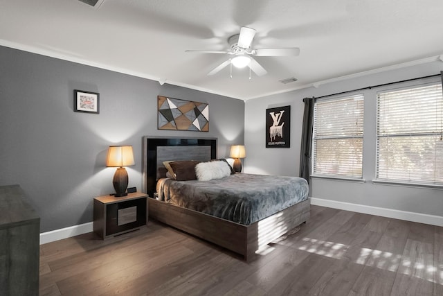 bedroom featuring visible vents, ornamental molding, a ceiling fan, wood finished floors, and baseboards