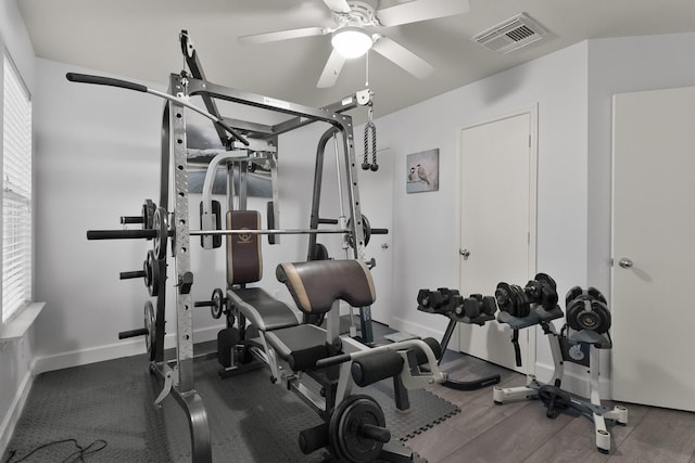 workout room with a ceiling fan, wood finished floors, baseboards, and visible vents