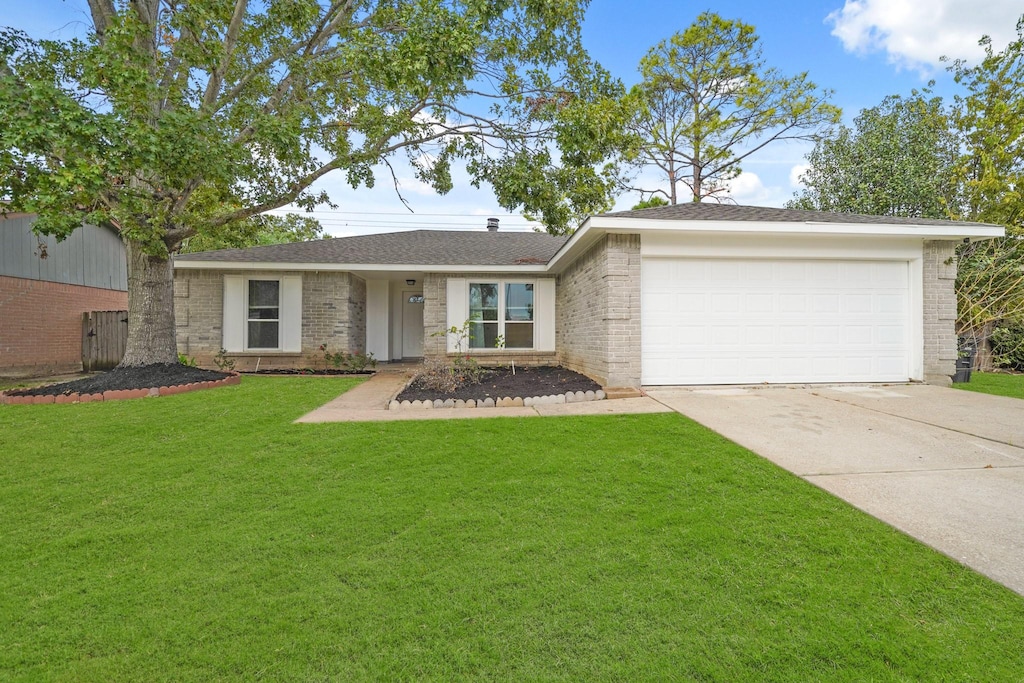 ranch-style house featuring a front lawn and a garage