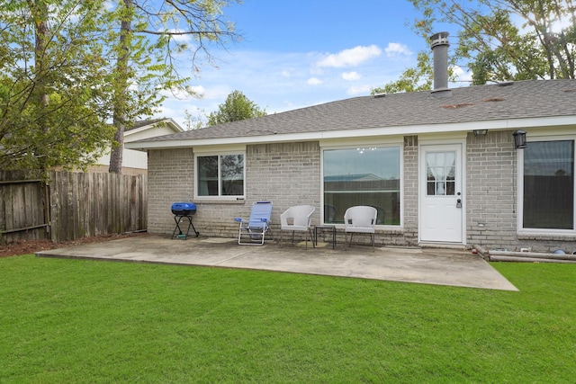 rear view of property featuring a patio area and a lawn