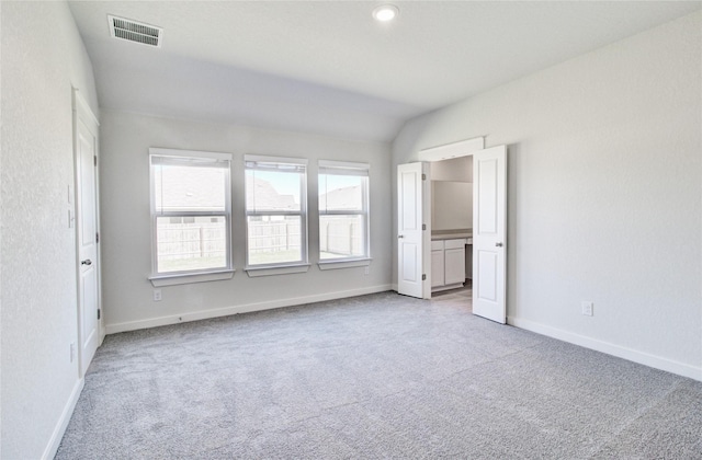 unfurnished bedroom with carpet and lofted ceiling