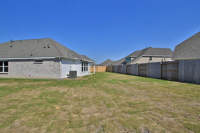 view of yard featuring central AC unit and fence