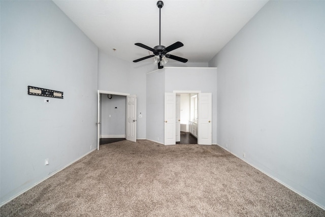 unfurnished bedroom featuring vaulted ceiling, carpet floors, ceiling fan, and ensuite bath