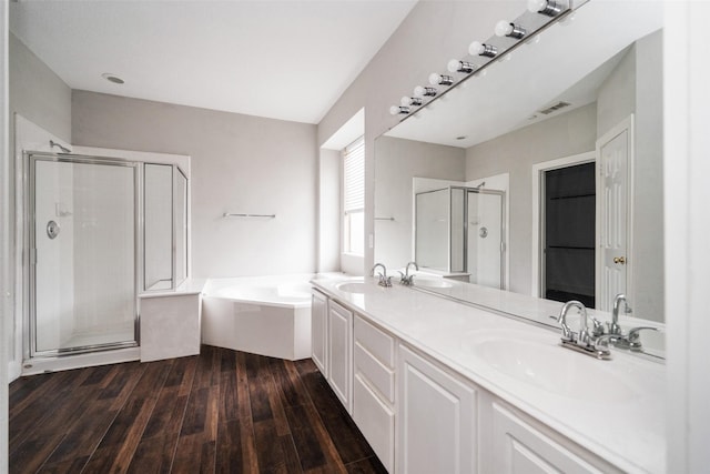 bathroom featuring hardwood / wood-style flooring, vanity, and plus walk in shower