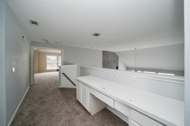 hallway with vaulted ceiling and carpet flooring