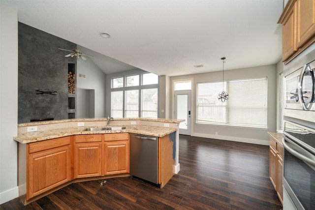 kitchen with sink, stainless steel appliances, light stone countertops, dark hardwood / wood-style flooring, and decorative light fixtures