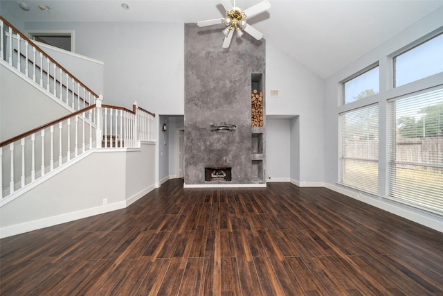 unfurnished living room featuring a fireplace, dark hardwood / wood-style floors, high vaulted ceiling, and ceiling fan