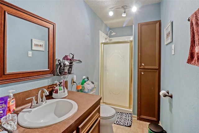 bathroom featuring a shower with door, vanity, a textured ceiling, and toilet