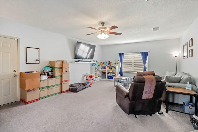 rec room featuring carpet flooring, ceiling fan, and a textured ceiling