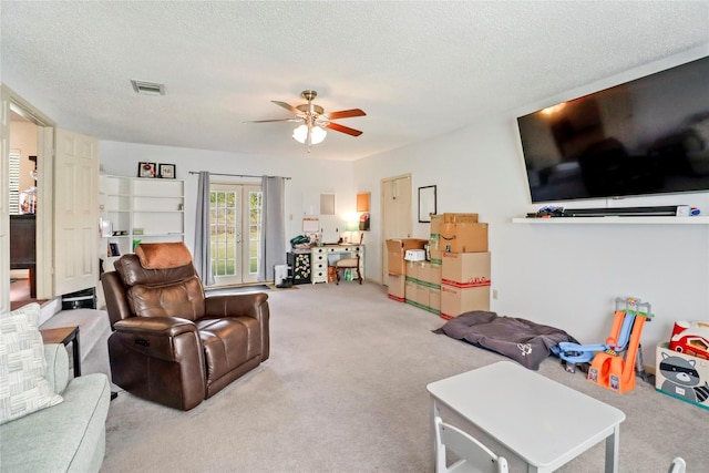 carpeted living room featuring a textured ceiling and ceiling fan