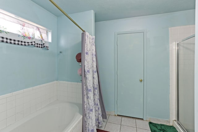 bathroom featuring tile patterned flooring, a textured ceiling, and plus walk in shower