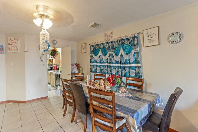 tiled dining area featuring a textured ceiling