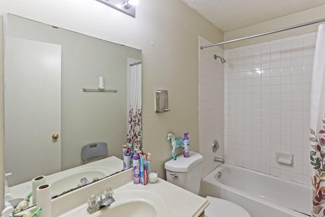 full bathroom with a textured ceiling, shower / bath combo, toilet, and sink