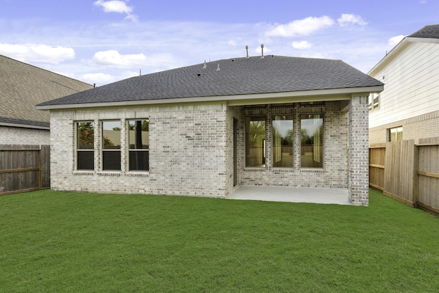 rear view of property featuring a yard and a patio