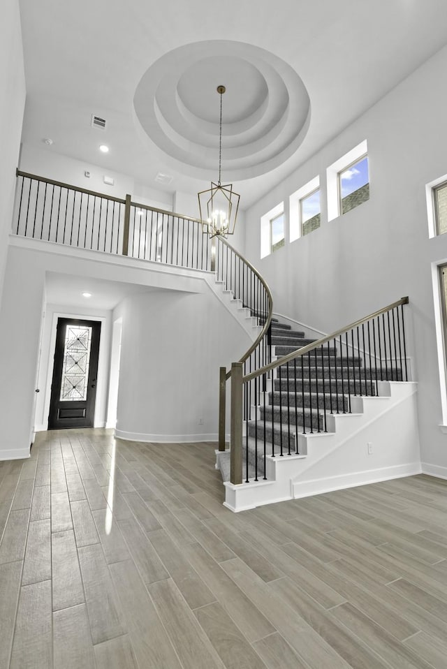 foyer entrance featuring hardwood / wood-style flooring, a towering ceiling, and a wealth of natural light