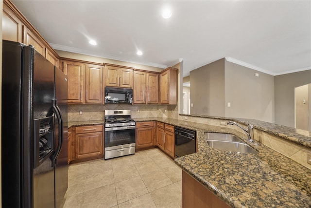 kitchen with black appliances, sink, dark stone countertops, tasteful backsplash, and kitchen peninsula