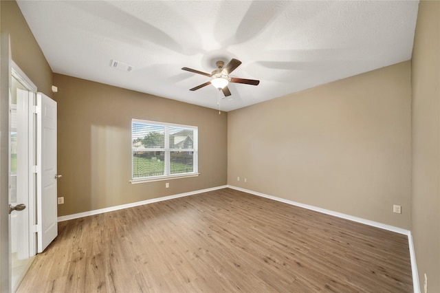 empty room featuring ceiling fan, a textured ceiling, and light wood-type flooring