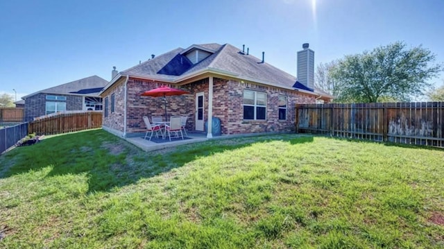 rear view of property featuring a yard and a patio area