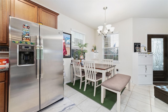 kitchen with pendant lighting, a notable chandelier, light tile patterned flooring, and stainless steel fridge with ice dispenser