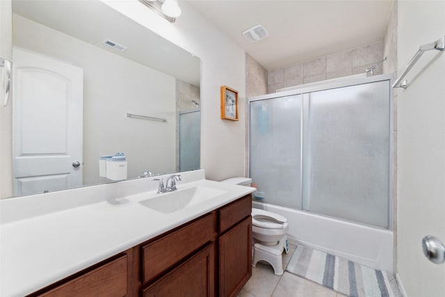 full bathroom featuring tile patterned flooring, combined bath / shower with glass door, toilet, and vanity