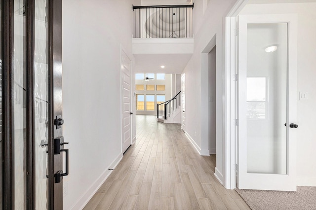 foyer entrance featuring light hardwood / wood-style flooring and a high ceiling