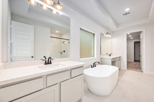 bathroom with vanity, a raised ceiling, and independent shower and bath