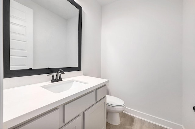 bathroom with vanity, toilet, and wood-type flooring