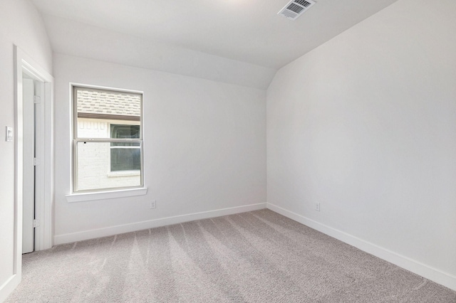 unfurnished room featuring carpet and vaulted ceiling