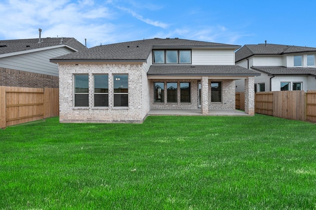 rear view of house with a yard and a patio