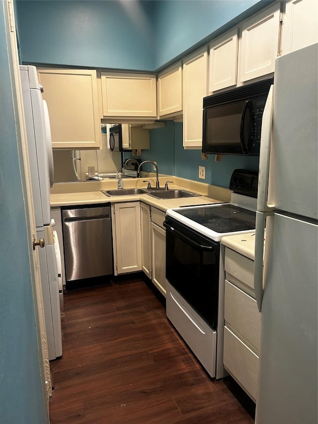 kitchen featuring white appliances, dark wood-type flooring, and sink