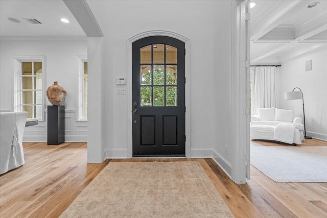 foyer featuring beamed ceiling, light hardwood / wood-style floors, coffered ceiling, and ornamental molding