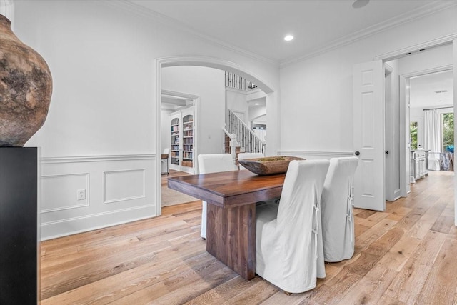 dining space featuring crown molding and light hardwood / wood-style floors