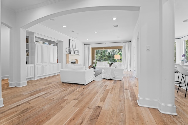 living room featuring crown molding and light wood-type flooring